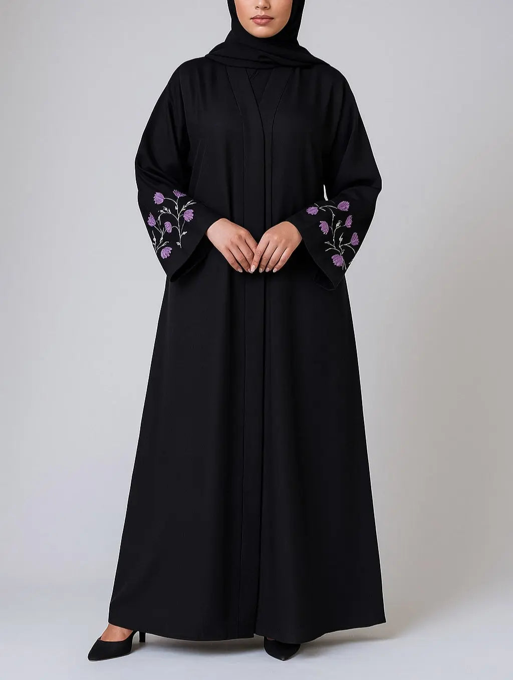 Woman wearing a black abaya with floral embroidery on sleeves